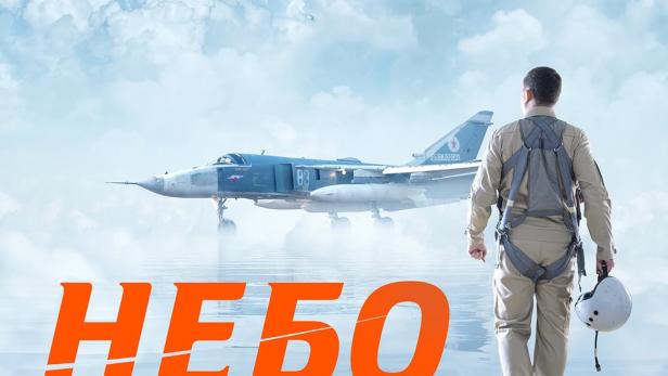 Ein Pilot geht in Richtung eines Kampfflugzeugs, während zwei weitere am Himmel fliegen.