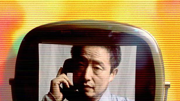 Das Poster für „Nam June Paik: Moon is the Oldest TV“ zeigt Paik auf einem Röhrenfernseher.
