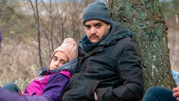 Ein Mann und ein Mädchen sitzen an einem Baum, möglicherweise im Zusammenhang mit dem „Usedom-Krimi: Drachenfrau“.
