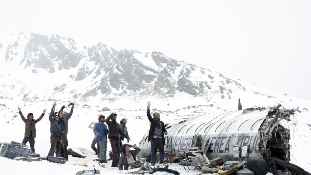 Überlebende eines Flugzeugabsturzes in den schneebedeckten Bergen neben dem Flugzeug-Wrack