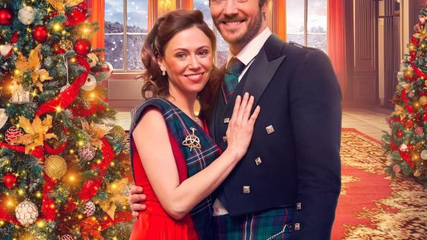 Das Filmplakat für „Christmas in Scotland“ zeigt Jill Winternitz und Dominic Watters vor einem Weihnachtsbaum.