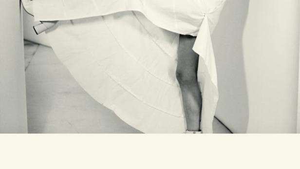 Schwarz-Weiß-Porträt von PJ Harvey im weißen Kleid, das für „à L’Olympia“ wirbt.