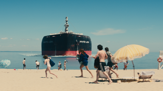 Ein Öltanker fährt auf einen Strand voller Menschen zu