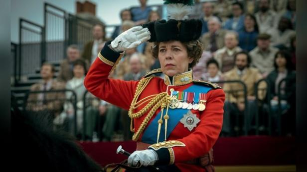 Olivia Colman als Queen Elizabeth II. in Militäruniform auf einem Pferd salutierend