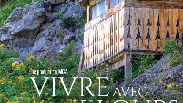 Ein Mann wandert in der Natur; im Hintergrund das Filmplakat „Vivre avec les loups“.