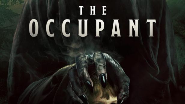 Ein unheimliches Wesen mit Kapuze legt seine Hände auf den Kopf eines Jungen.