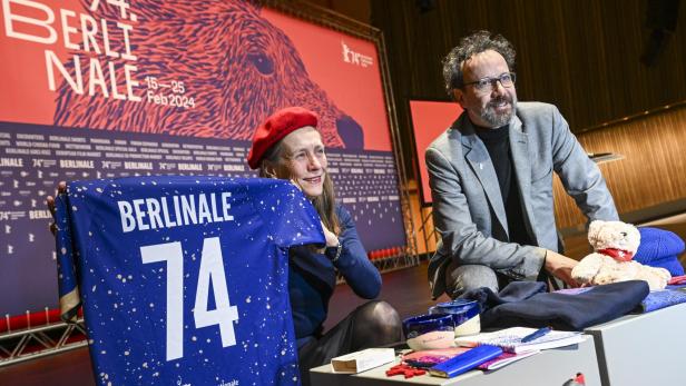 Das Leitungs-Duo der Berlinale, Mariette Rissenbeek, Geschäftsführerin, und Carlo Chatrian, künstlerischer Direktor, stehen vor Beginn der Pressekonferenz zur Vorstellung Bekanntgabe des Berlinale-Programms 2024 mit Merchandiseartikeln der Berlinale auf der Bühne. Foto: Jens Kalaene/dpa +++ dpa-Bildfunk +++.