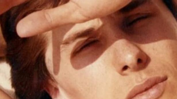 Ein Mann schirmt seine Augen mit der Hand vor der Sonne ab.