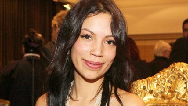 Gisele Oppermann wurde 2008 als "Heulsuse" der Nation verspottet. Elf Jahre später traute sie sich trotzdem ins Dschungelcamp, wo die Zuschauer sie in neun Prüfungen wählten. Eine Frau mit braunen Haaren vor einem goldenen Hintergrund