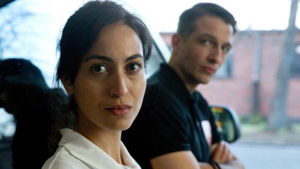 Eine Notärztin namens Emily mit einem Kollegen im Hintergrund.