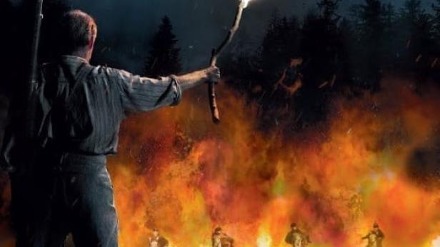 Ein Mann mit Fackel und Gewehr vor einer brennenden Kulisse mit Reitern für den Film „The Last Front“.