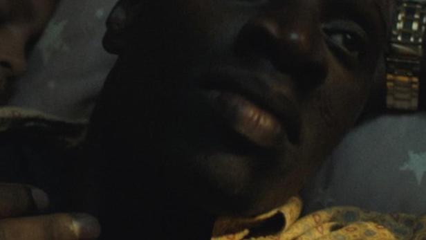 Ein Mann liegt mit einem gemusterten Hemd auf einem Kissen mit Sternenmuster.