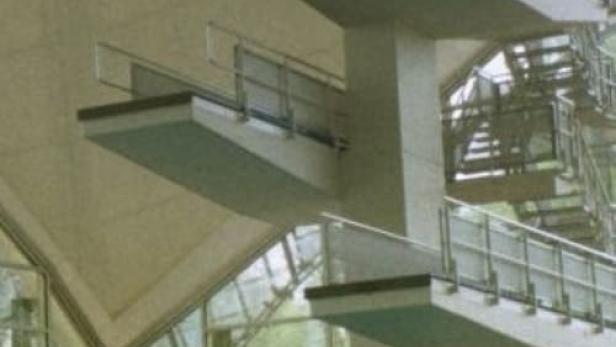 Ein Mädchen steht auf dem höchsten Sprungturm in einem Schwimmbad.