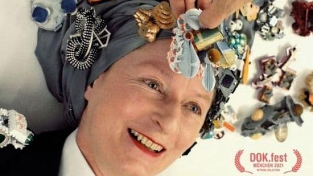 Das Filmplakat für „Hunter from Elsewhere: A Journey with Helen Britton“ zeigt Helen Britton mit Schmuck auf dem Kopf.