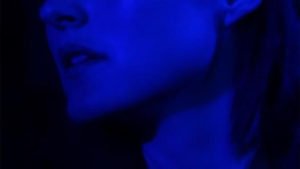 Das blau beleuchtete Gesicht einer Frau, möglicherweise ein Filmplakat für „Another End“.