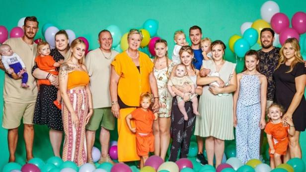 "Die Wollnys", eine der bekanntesten TV-Familien Vor einer türkisenen Wand steht eine Großfamilie mit mehr als 20 Personen