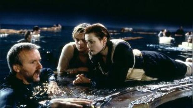 Regisseur James Cameron (l.), Leonardo DiCaprio und Kate Winslet am Set von &quot;Titanic&quot; mit der berühmt-berüchtigten Tür.