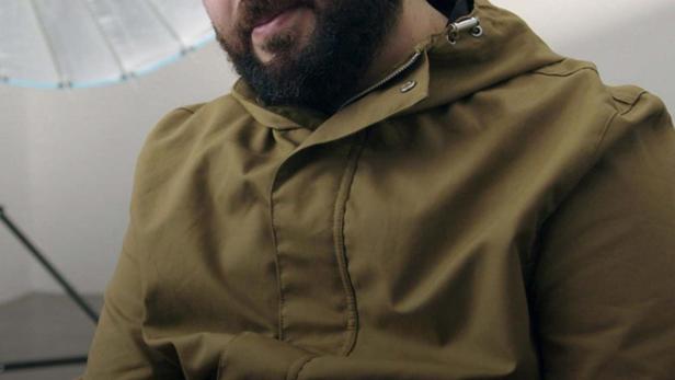 Ein Mann mit Bart und lockigem Haar vor einem Studiolicht, möglicherweise im Zusammenhang mit „Teheran Connection“.