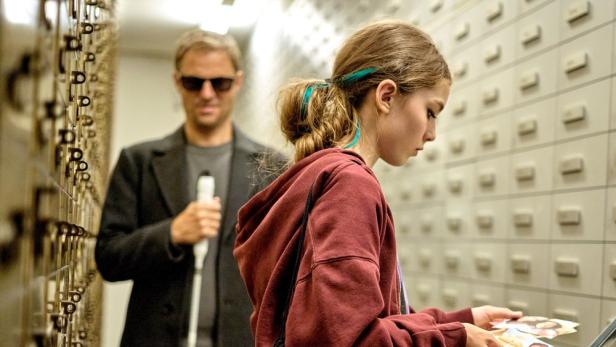 Ein blindes Ermittlerteam steht vor einem Karteikasten.