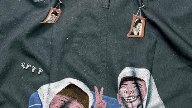 Eine Uniform mit der Aufschrift „Our Uniform“ und Zeichnungen von drei Mädchen mit Kopftüchern.