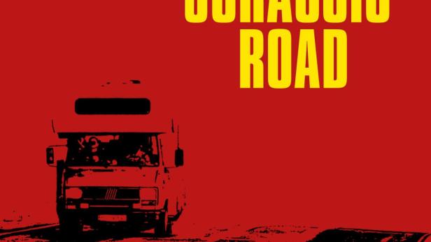 Ein Wohnmobil fährt auf einer Straße unter dem gelben Schriftzug „Jurassic Road“ und einem Dinosaurier mit Sternen.