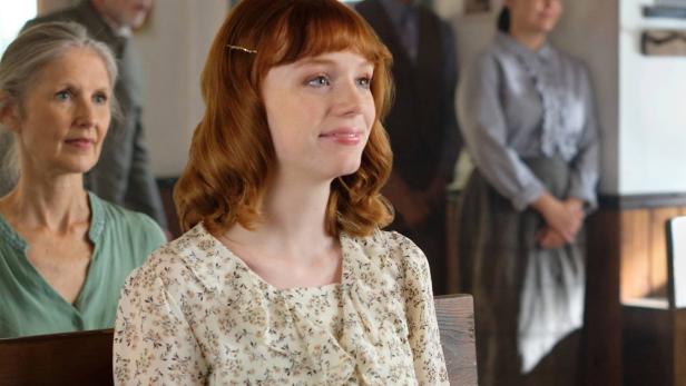 Mamie Laverock sitzt in einem Raum mit anderen Personen.