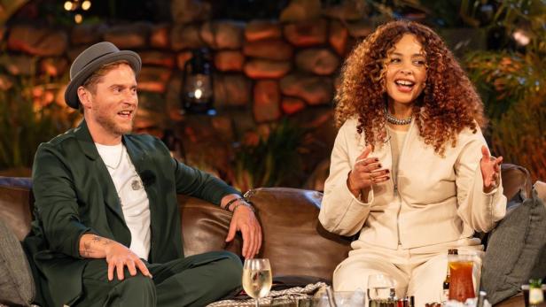 Zwei Personen sitzen auf einer Couch und unterhalten sich angeregt.