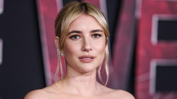 Porträt von Emma Roberts mit blonden Haaren und Ohrringen.