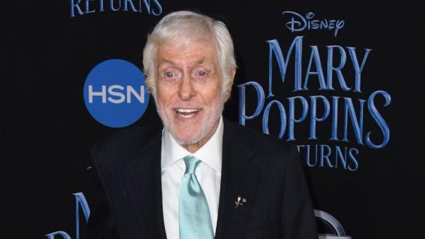 Dick Van Dyke posiert vor einem „Mary Poppins Returns“-Hintergrund.