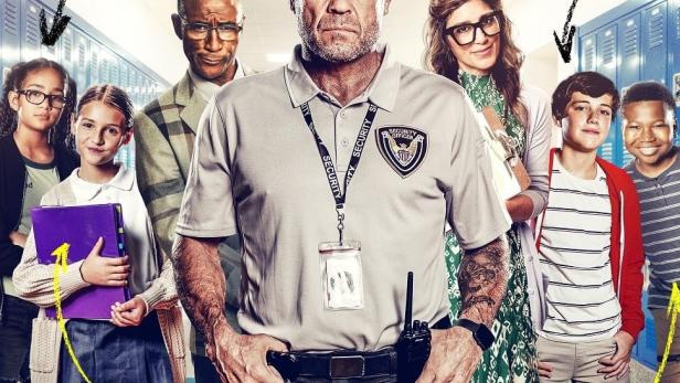Das Filmplakat zu „F+“ zeigt Randy Couture als Sicherheitsbeamten mit Schülern und Drohnen.