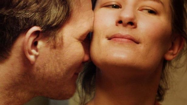 Ein Mann schmiegt sich an die Wange einer Frau.