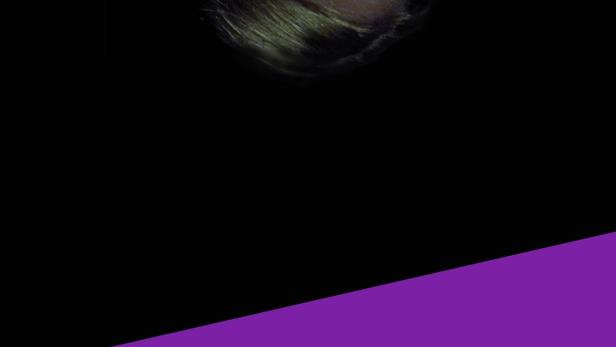 Eine junge Frau hält ein Telefon an ihr Ohr.