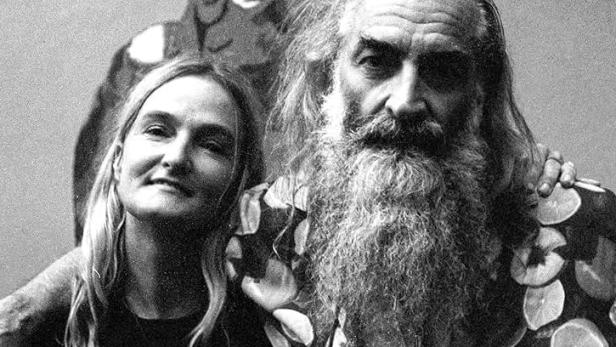 Ein Schwarzweißfoto von zwei Personen vor einem Schild mit der Aufschrift „Ellis Park“ und einem Affen.