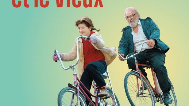 Ein junges Mädchen und ein älterer Mann fahren nebeneinander auf Fahrrädern.