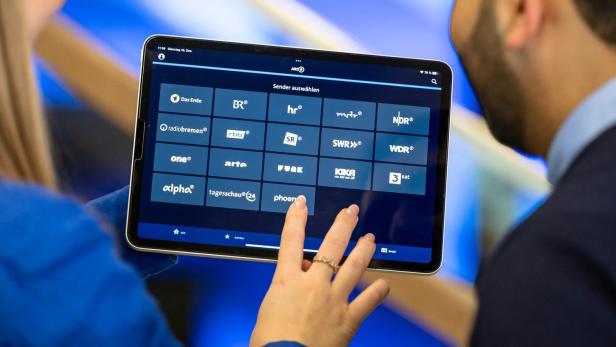 Eine Person wählt auf einem Tablet einen Fernsehsender aus.