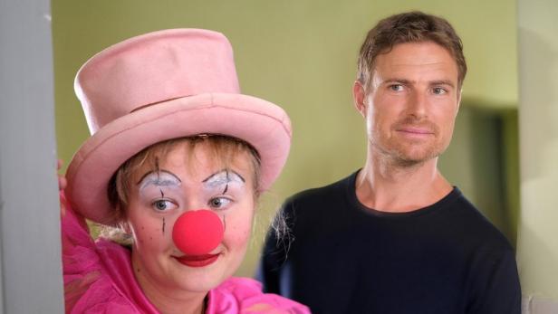 Eine Frau als Clown verkleidet und ein Mann stehen nebeneinander.