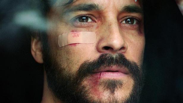 Das Filmplakat von „Im Rosengarten“ zeigt Kostja Ullmann mit Verletzungen im Gesicht.