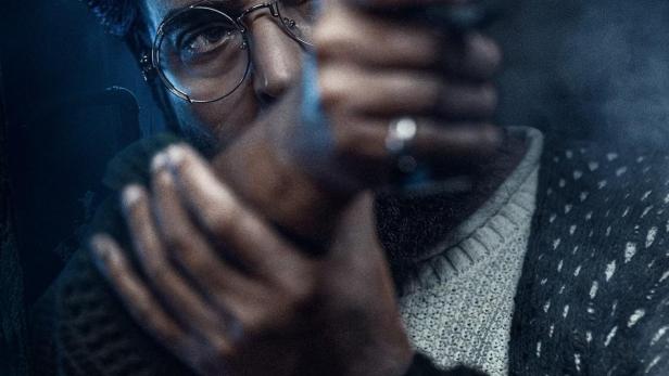 Ein Mann mit Brille zielt mit einer Pistole, im Vordergrund der Schriftzug „Bazooka“.