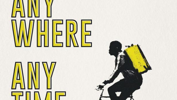 Ein Fahrradkurier mit gelbem Rucksack fährt auf einem Fahrrad.