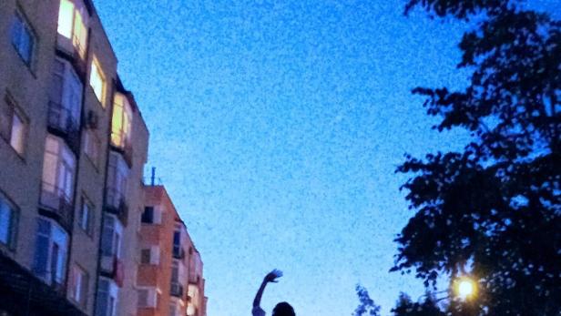 Das Filmplakat für „Pluto“ von Matas Kaikaris zeigt eine Person mit erhobenem Arm bei Nacht.