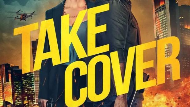 Das Filmplakat für „Take Cover“ zeigt Scott Adkins und Alice Eve mit Waffen vor einer zerstörten Stadt.