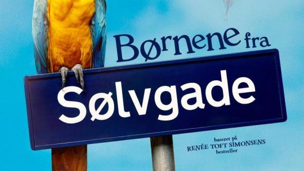 Ein Ara sitzt auf einem Schild für den Film „Børnene fra Sølvgade“.