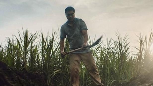 Ein Mann gräbt mit einer Hacke in der Nähe eines Grabes, im Hintergrund das Netflix-Logo und japanische Schriftzeichen.