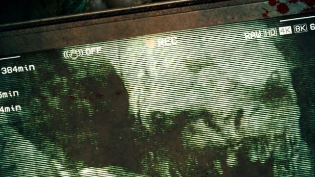 Ein Überwachungsmonitor zeigt ein verzerrtes Bild eines Schädels mit dem roten Schriftzug „Basement“ darüber.