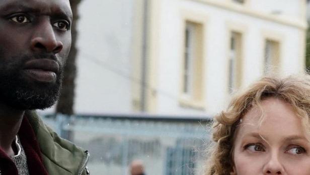 Omar Sy und Vanessa Paradis stehen vor einem Haus.