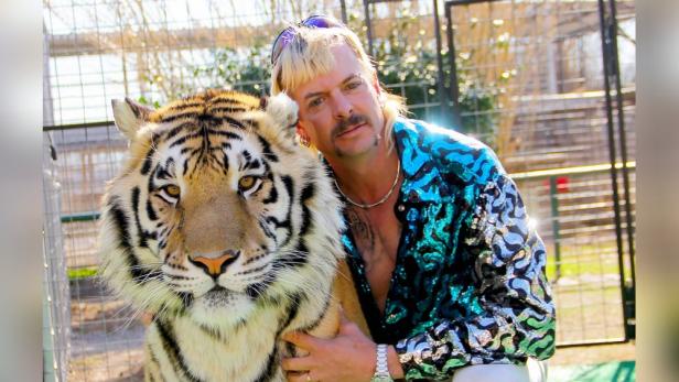 Joe Exotic umarmt einen Tiger.