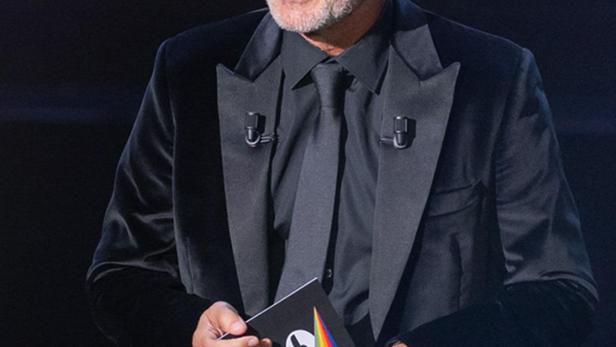 Ein Mann im Anzug hält eine Broschüre von Canal+ in der Hand.
