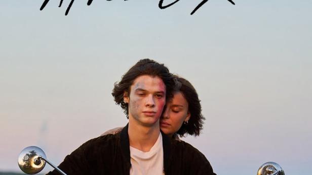 Ein junges Paar fährt auf einem Motorrad auf einer Landstraße; Filmposter „Leurs enfants après eux“.