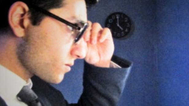 Das Filmplakat für „Afterglow“ zeigt einen Mann mit Brille im Anzug.