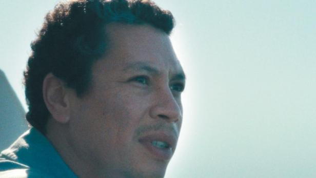 Ein Mann blickt auf dem Filmplakat für „La Mer au loin“ aufs Meer.